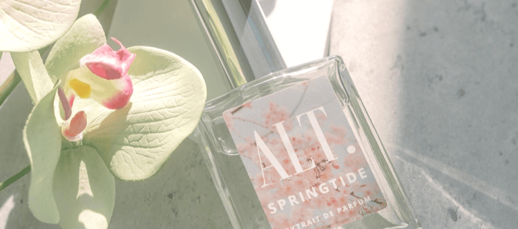 Perfume bottle beside flower